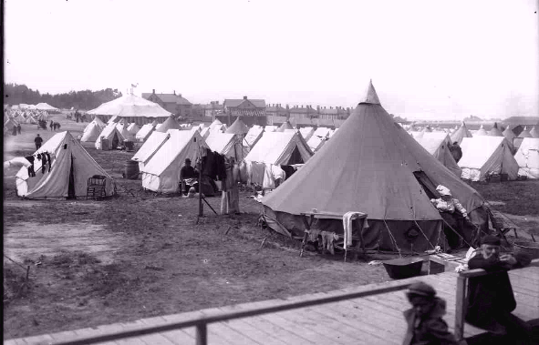 A large circus tent stands in the field in front
      of the U.S. Army General Hospital at the Presidio of San Francisco.